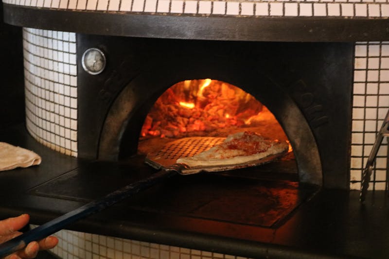 Wood-fired pizza slice fresh from the oven at Pizzana